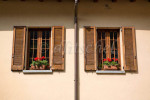 Detail of typical Italiian windows with louvered shutters and geraniums in window boxes in the Lake Como village of Varenna, Italy. To purchase this image, please go to my stock agency click here.
