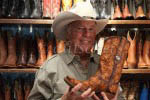 Roy Flynn owner of Boots & Boogie, a cowboy boot store in  downtown Santa Fe, New Mexico, USA, displays one of his better boots for sale.