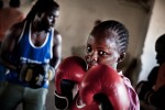 At 13, Tabitha Njeri will lead the ‘Life Skills’ classes after training has finished. Amongst many things, ‘Life Skills’ involve confidence building, sexual health education and gender role debates. Priest, her boxing teacher, mentor and trainer spas in the background.