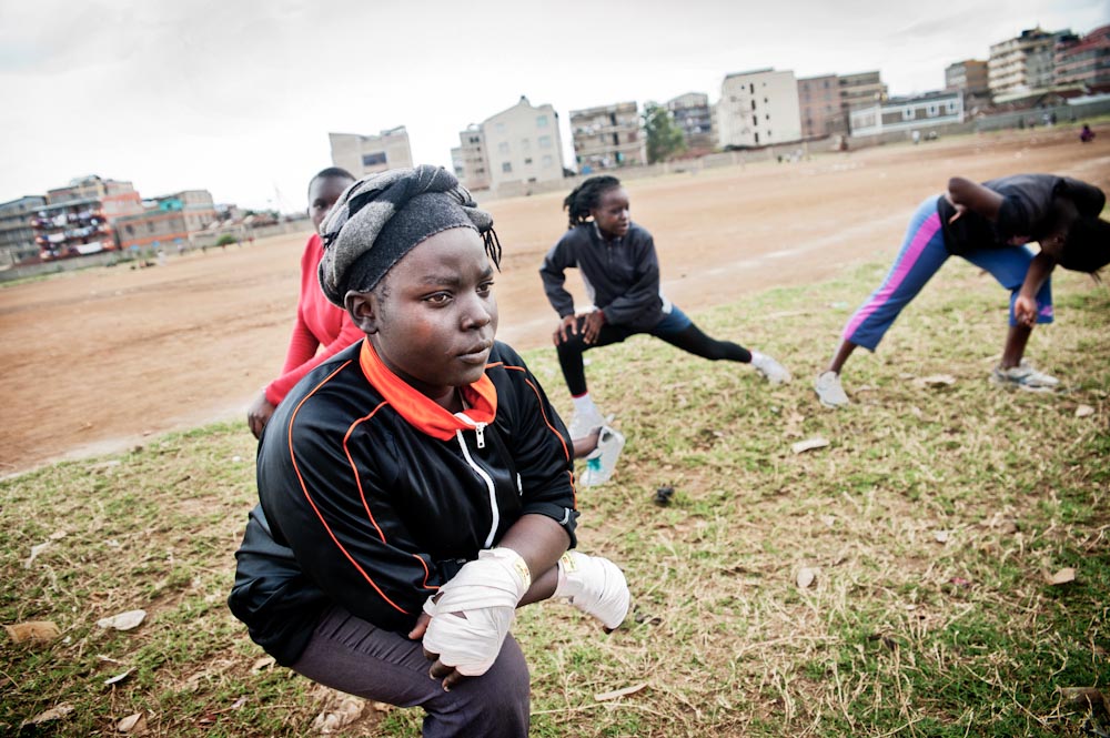 Boxgirls warm up in a field outside the community centre in Kariobangi slum.