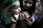 Along side the worship, various socio-religious functions take place, such as competitions for the best dancer or the best dressed individual.Here a baby is made up for the competition.