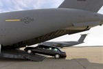 A Presidential limousine is loaded onto a C5 military transport plane bound for eastern Europe, where President Bush is headed next week.  A {quote}secure package{quote} of motorcade vehicles, including the limousines and a fleet of Secret Service SUVs is transported to the site of every presidential visit. Photo by Brooks Kraft/Corbis