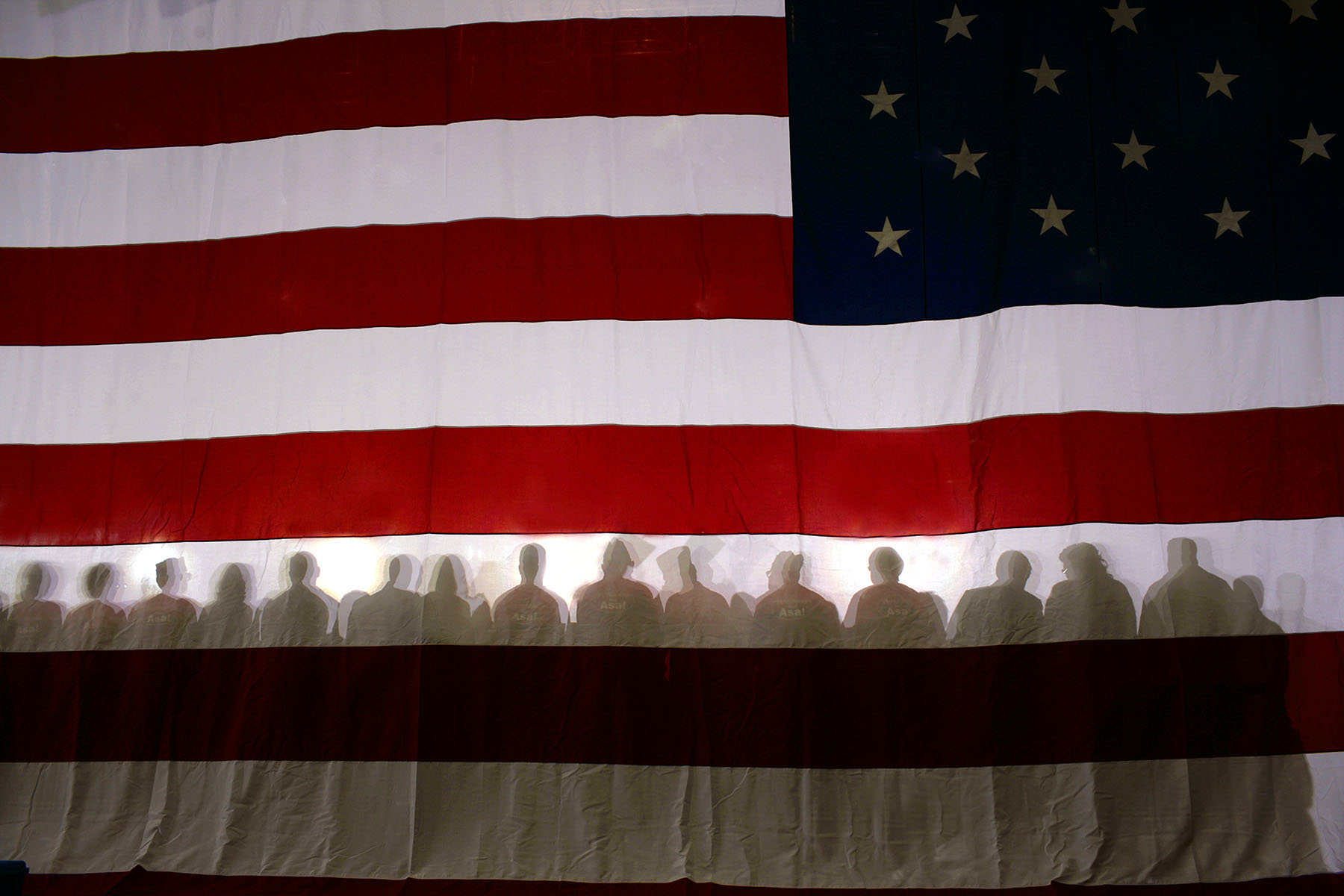Supporters sit in front of an AMerican flag while listening to President George W. Bush speak at a Republican Party congressional mid-term election campaign rally in Bentonville, Arkansas, November 6, 2006.Photo by Brooks Kraft/Corbis