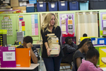 Sixth grade teacher Erin Henry carries books to be distributed for open reading as her students take a vocabulary quiz at Beulah Shoesmith Elementary School, October 7, 2016.