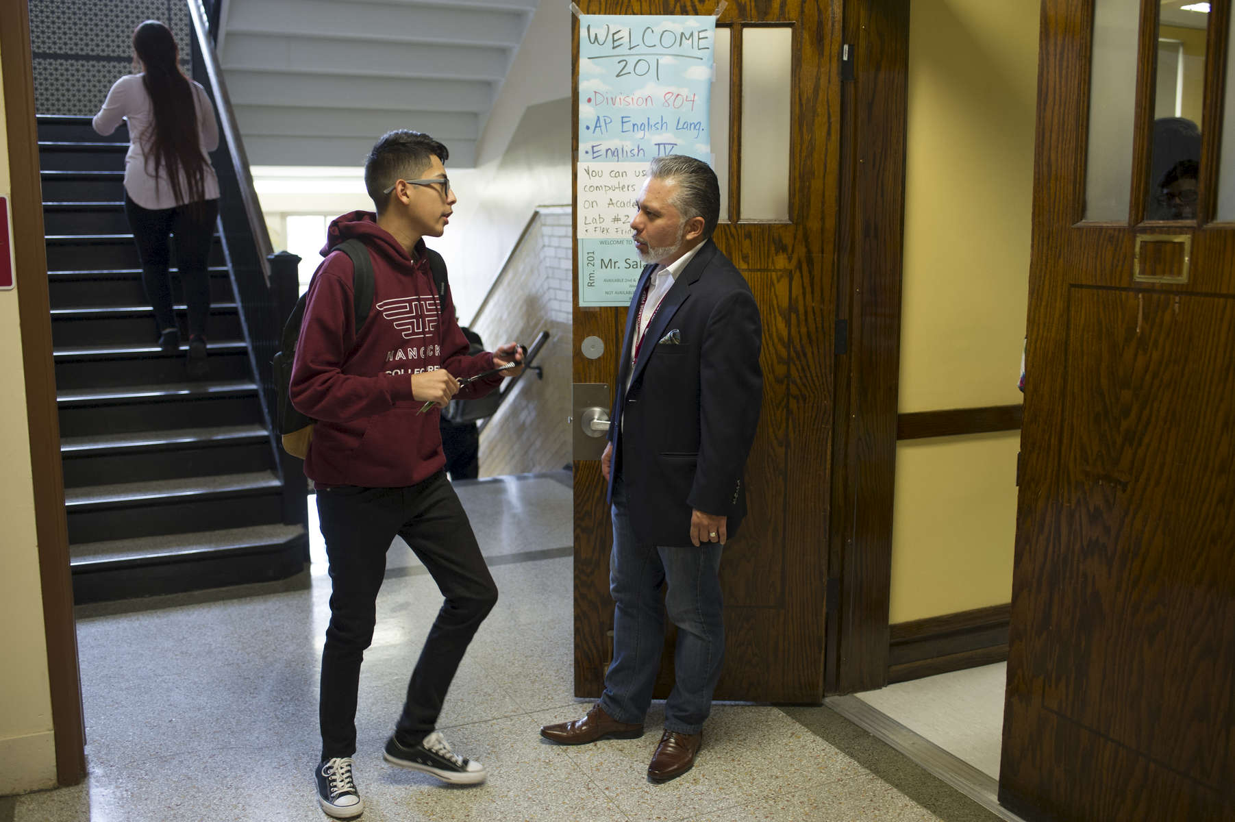 English teacher Ray Salazar speaks with a student during a transition period about missing assignments at John Hancock College Prep High School October 3, 2016.