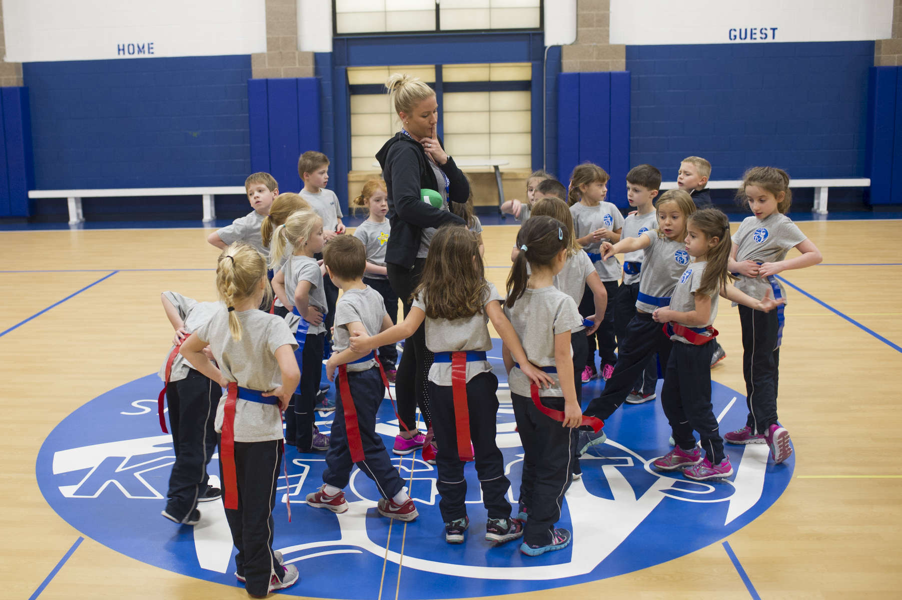 First grade students gather around physical education teacher Katie Krupa as she prepares to teach them flag-football in the gymnasium at St. Mary of the Woods Catholic School in the Edgewater neighborhood of Chicago, November 11, 2016.