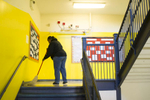 Custodian Sirena Buchanan sweeps a landing on a staircase of the University of Chicago Charter Schools North Kenwood Oakland Campus, November 16, 2016.
