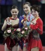 Figure skating medalists Sasha Cohen, of the USA, Shizuka Arakaw, of Japan, and Irina Slutskaya, of Russia, together on the medals stand following the ladies' free skating program at the 2006 Winter Olympics in Turin, Italy.