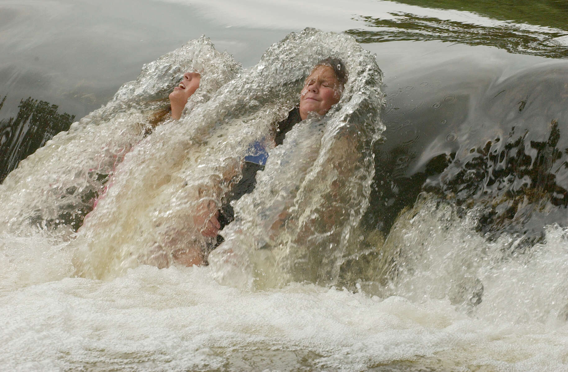 Lauren Smosynski (left) 13, and her friend Heather Aiken, 13, cool off in the Brandywine Creek on July 14, 2004.
