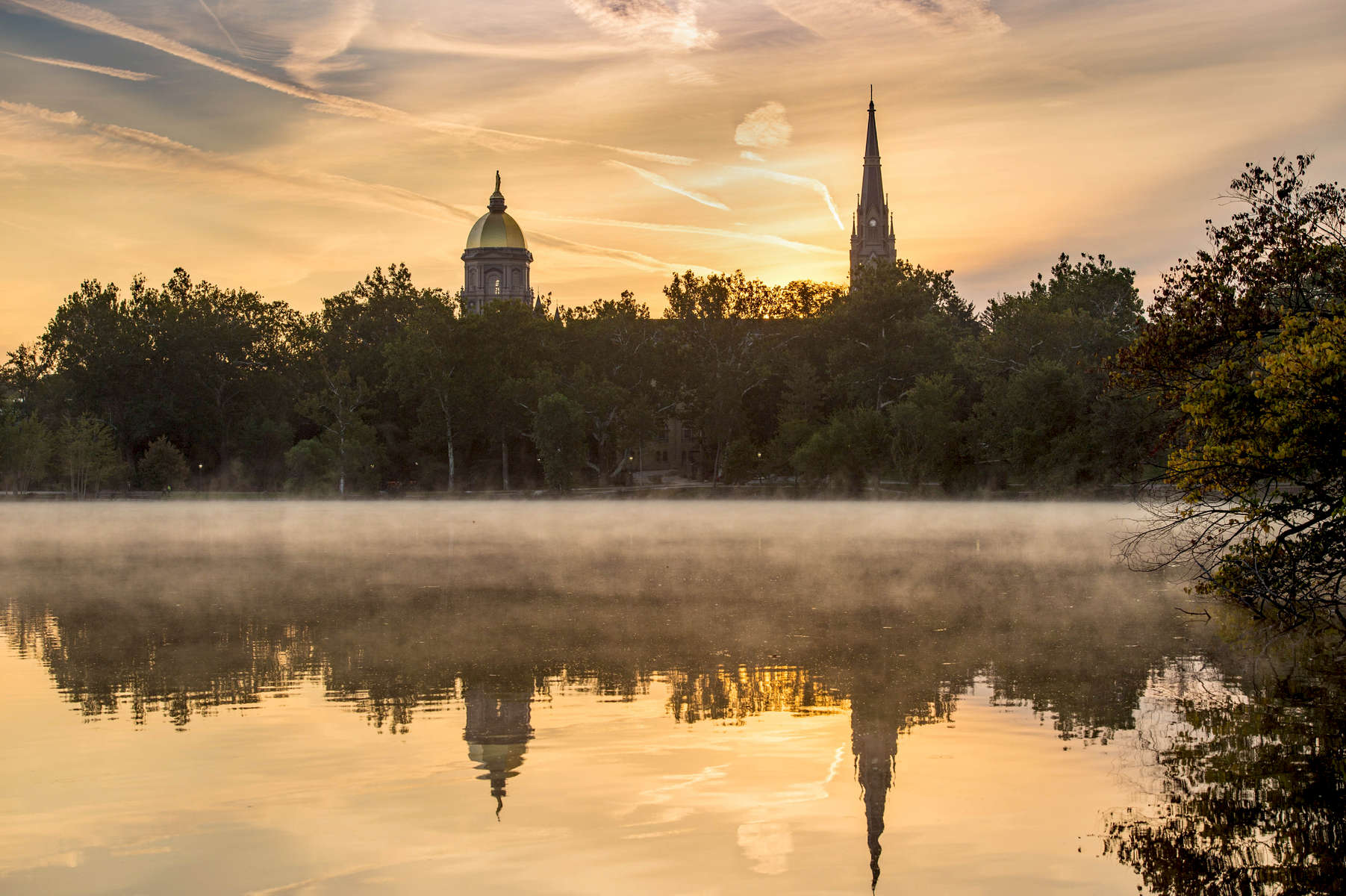 September 12, 2017; View of sunrise from St. Mary's Lake of the Golden Dome and the steeple of the Basilica of the Sacred Heart.  (Photo by Barbara Johnston/University of Notre Dame)