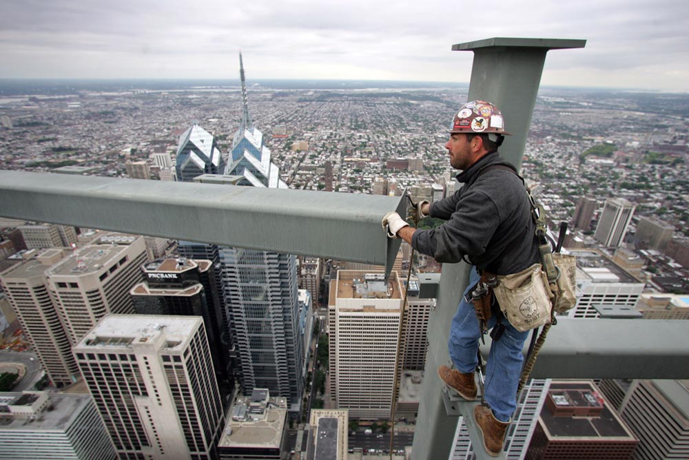 An ironworker guides a steel beam into place on the 55th floor of the Comcast Tower.