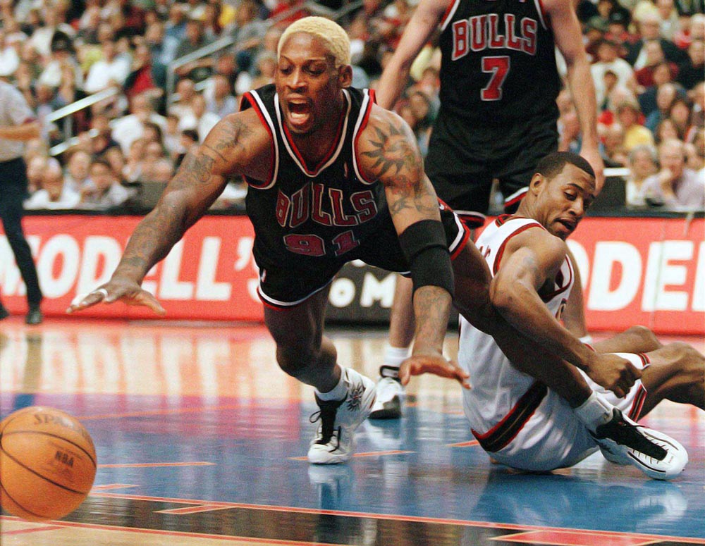 Chicago Bulls' Dennis Rodman dives for the ball as Philadelphia 76ers' Aaron McKie (right) defends on the play during first quarter action.