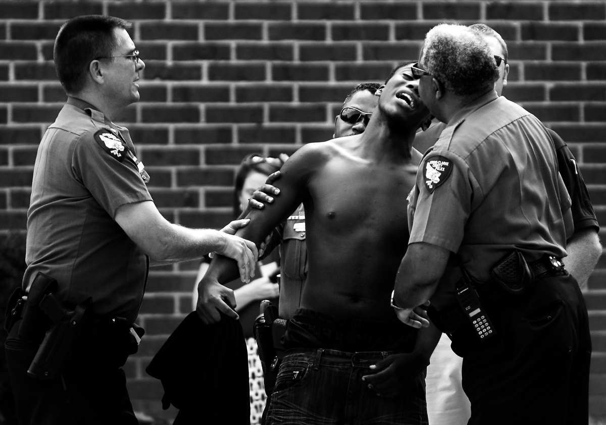 Athens-Clarke Police Major Mark Sizemore, left and Capt. Clarence Holeman, right, try to console the friend of 20-year-old Chateaubrian L. {quote}Toby{quote} Bailey who was shot to death in the 130 building of Bethel Midtown Village on Friday, August 27, 2010 in Athens, Ga.  