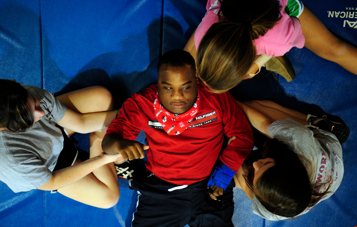 Issac Wyatt, center, is helped with situps by students Zoe Katz, left, Crockett Floyd, top, and Paige Maddox, right, during an adaptive physical education class at Malcom Bridge Middle School on Thursday, November 18, 2010 in Bogart, Ga.  Eighth grade students help disabled students exercise during the three day-a-week program.