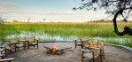 Fire pit at Abu Camp. Early morning breakfasts, high tea, sundowners, and dinner can be enjoyed in this open air setting. Abu Camp is a Wilderness Safari's Collection Camp in the Okavango Delta, Botswana. Photo © 2012 Jay Graham, all rights reserved