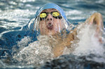 Troy DeMoss of Shawnee Mission East High School competes in the 100 yard backstroke.