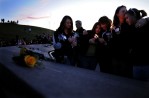 Relatives of slain Columbine High School teacher, David Sanders, granddaughter Mallory Sanders, 17, center, is embraced by mother, Coni Sanders, as her sister, Cindy Thirouin, second from right, kisses her daughter, Tiffany Strole, 15, during a candlelight vigil at the Columbine Memorial at Clement Park in Littleton, Colo. Sunday 04/19/09 in honor of the tenth anniversary of the school shooting which is Monday. (PHOTO BY MATT MCCLAIN)