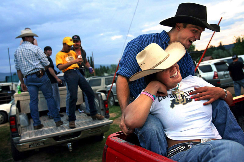 Chad Wiltfang, 22, holds his girlfriend, Brittany Moon, 22, in the back of a pickup truck Thursday August 2, 2007 as they watch cowboys compete during the Carbondale, Colo. Wild West Rodeo Series.  Many locals are concerned that the influx of gas workers may change their way of life.  Photo by Matt McClain