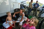 Frances Hoffpowier, center left, feeds her youngest son, Mason, 2, as her daughter Chloe, 4, takes a drink of soda while the families' father, Michael Hoffpowier, talks with fellow natural gas worker, Tommy Jones at the River Camp RV Park outside of Meeker, Colo.  The family moved from Texas so Michael could make better money as a welder in the gas fields.  Gas workers see a conflict between themselves and locals in the community they now call home.  {quote}The people here have absolutely no use for us,{quote} Hoffpowier said.  Photo by Matt McClain
