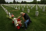 Lt. Col. Robert Thompson kneels and cries in Fort Logan National Cemetery in Denver, Colo. next to the grave of Master Srgt. Robert West, who he served with in Iraq.  Thompson was with West when he was killed by an IED south of Baghdad in 2006.  Photo by Matt McClain