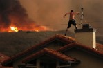 Nathan Graham video tapes an approaching brush fire on top of the Las Virgenes Townhouses in Calabasas, Calif.  Photo by Matt McClain