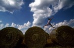 Leaping from hay bales, Erin Mencher, 9, plays in a field near her family's Bloomington, Ind. home on a fall afternoon.  Photo by Matt McClain