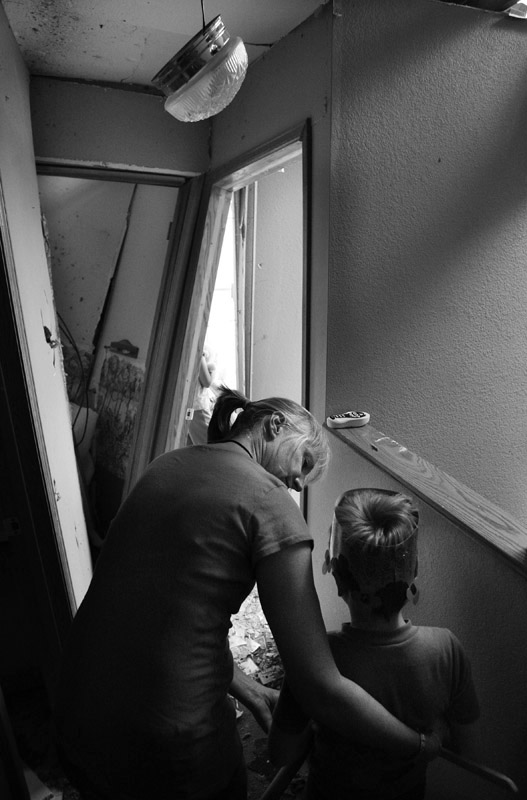 Days after the tornado, Maggie Barnhill tries to coax her son, Riley Barnhill, 6, to see his tornado damaged room for the first time after returning to the family's home.  Riley and Maggie were at home when the tornado damaged their home.  Photo by Matt McClain