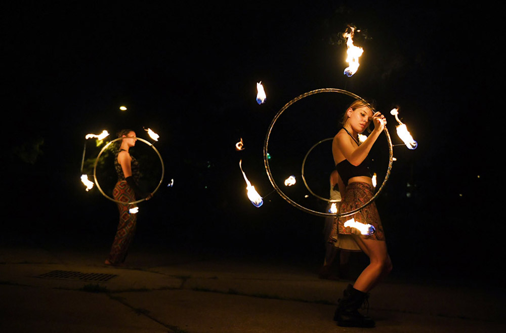 Rosemary Cornelius, left, and Lydia Russell, right, take part in a practice with the group, Revolutionary Motion at Old City Farm and Guild on Thursday August 11, 2016 in Washington, DC. The group is preparing to perform a fire based routine at Burning Man in Nevada. (Photo by Matt McClain/ The Washington Post)