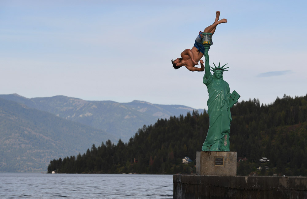 Jacob Clad, 22, flips into Lake Pend Oreille from a replica of the Statue of Liberty on Wednesday June 22, 2016 in Sandpoint, ID. (Photo by Matt McClain/ The Washington Post)