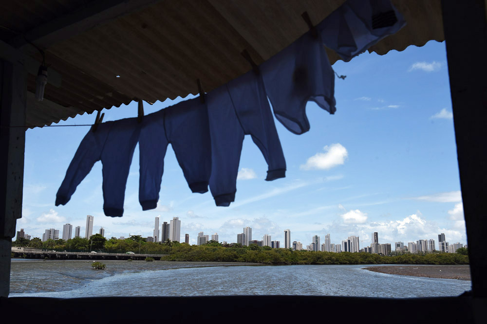 Clothes hang from a line at the home of Jessica Thalia Cruz Menezes on Sunday March 13, 2016 in Recife, Brazil. Jessica is eight months pregnant and has had no signs of the Zika virus. The Zika virus has been rampant in this region. The virus is spread by the Aedes aegypti mosquito. Trash and stagnant water are breeding grounds for mosquitos. (Photo by Matt McClain/ The Washington Post)
