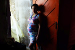 Jessica Thalia Cruz Menezes poses for a portrait at her home in a community along the water on Sunday March 13, 2016 in Recife, Brazil. Jessica is eight months pregnant and has had no signs of the Zika virus. The Zika virus has been rampant in this region. The virus is spread by the Aedes aegypti mosquito. Trash and stagnant water are breeding grounds for mosquitos. (Photo by Matt McClain/ The Washington Post)