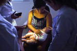 Cheane Stephany Da Silva holds Maria Eduarda Rodrigues Pereira, three months, as her eyes are examined at Fundacao Altino Ventura on Thursday March 17, 2016 in Recife, Brazil. The Zika virus is rampant in the region. Maria was born with microcephaly. The Zika virus has been linked to the condition. Cheane helps to raise the child along with her Maria's guardian who adopted the baby. (Photo by Matt McClain/ The Washington Post)
