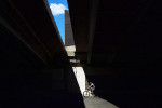 A bicyclist is illuminated as he rides under the Woodrow Wilson Memorial Bridge on Sunday August 7, 2016 in Alexandria, VA. (Photo by Matt McClain/ The Washington Post)