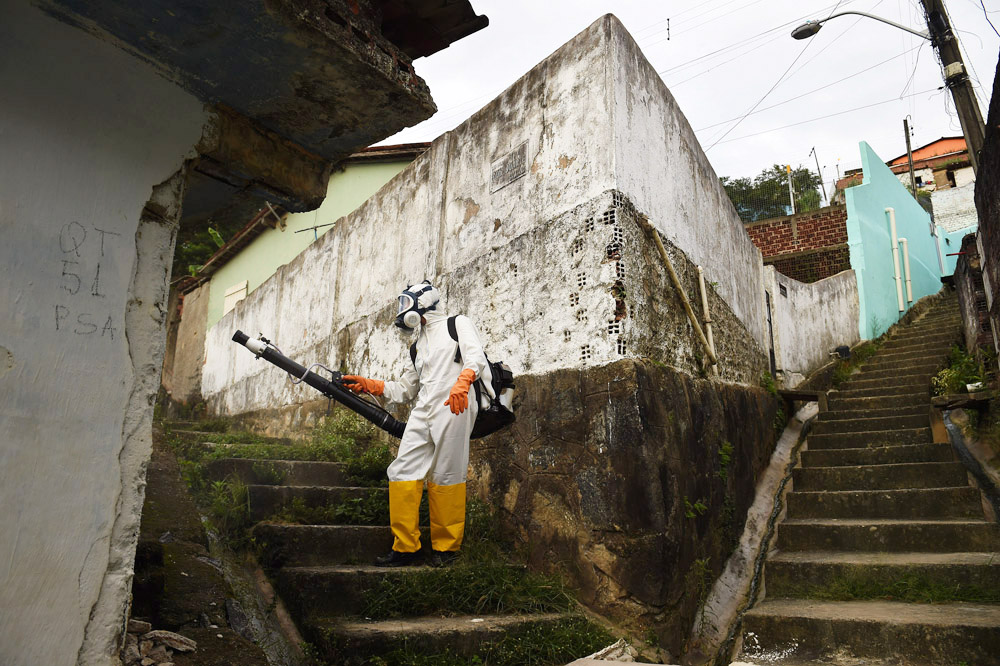 A worker fumigates the Guabiraba neighborhood for mosquitos on Wednesday March 16, 2016 in Recife, Brazil. The Zika virus is rampant in the region. The Zika virus has been rampant in this region. The virus is spread by the Aedes aegypti mosquito. (Photo by Matt McClain/ The Washington Post)
