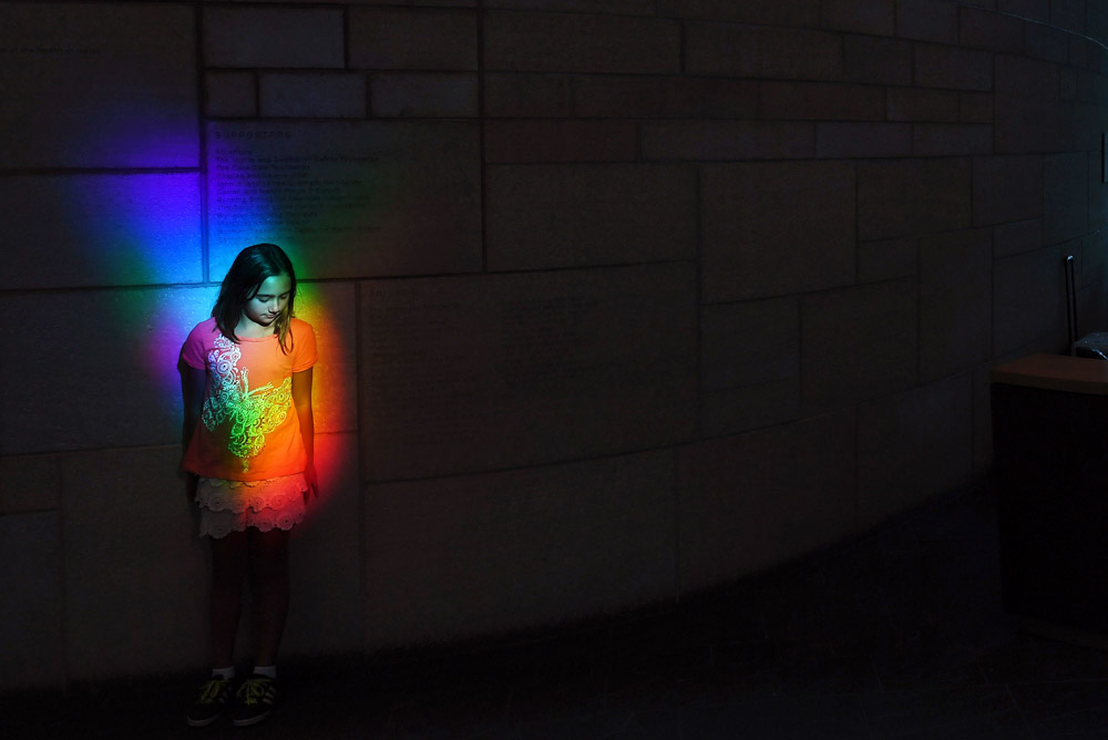 Isabella Garland, 9, of Baltimore, MD is illuminated by a rainbow created by prisms at the Smithsonian National Museum of the American Indian on Monday August 15, 2016 in Washington, DC. (Photo by Matt McClain/ The Washington Post)