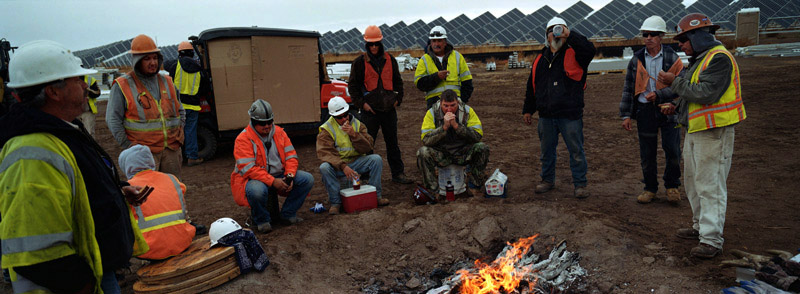 Workers keep warm near a fire during a break while working at the Greater Sanhill Solar Project being constructed by SunPower Corporation outside of Alamosa, Colo. on Thursday 10/21/10.  Photo by Matt McClain