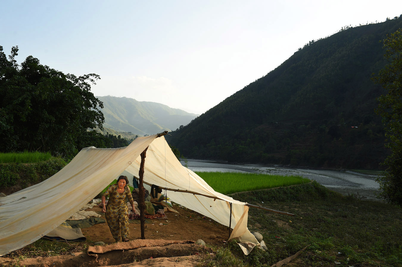 A woman walks out of a tent nestled in a scenic spot on Sunday May 03, 2015 in the Nuwakot District of Nepal. A deadly earthquake in Nepal has killed thousands. Tent encampments are a common sight as people have lost their homes or are afraid to return to them because of earthquake damage. (Photo by Matt McClain/ The Washington Post)