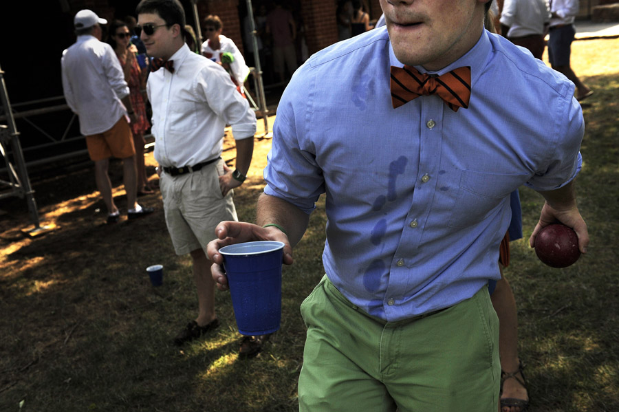 Thomas Howard, left, looks on as Patrick Greco, right, plays bocce ball before a college ball at the University of Virginia on Saturday August 31, 2013 in Charlottesville, VA.  The University of Virginia has a tradition of members of the student body dressing up for game day.  The tradition is called, {quote}guys in ties, girls in pearls{quote}.  (Photo by Matt McClain/ The Washington Post)