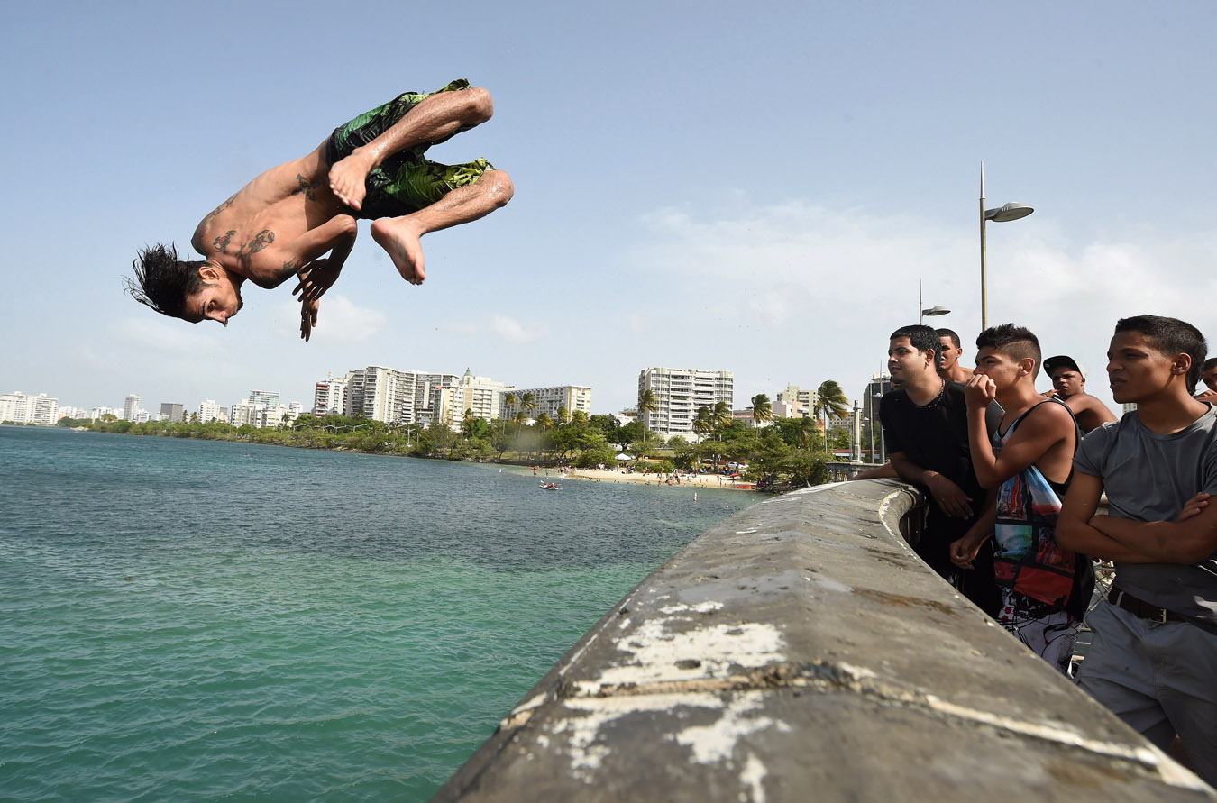 Rafael Velez jumps from a bridge into Laguna del Condado on Saturday July 04, 2015 in San Juan, Puerto Rico. Many people headed to local beaches and waterways to spend the Fourth of July. (Photo by Matt McClain/ The Washington Post)