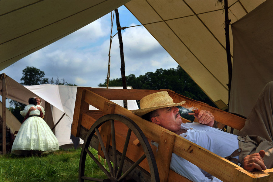 Tony Stracuzzi of Stuart, FL relaxes in a wagon as he smokes a pipe prior to a reenactment of Pickett's Charge that was put on by the Blue Gray Alliance on Sunday June 30, 2013 outside of Gettysburg, PA.  This is one of several events that is commemorating the 150th anniversary of the Battle of Gettysburg.  Considered a major event of the Civil War.  (Photo by Matt McClain/ The Washington Post)