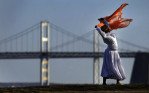 The Chesapeake Bay Bridge is seen in the background as Lisa Oliver performs liturgical dance moves while she is photographed by a friend to create a portfolio for Oliver on Wednesday March 14, 2012 at Sandy Point State Park in Annapolis, MD.  Temperatures soared in the high 70's near 80 degrees on Wednesday.  (Photo by Matt McClain for The Washington Post)