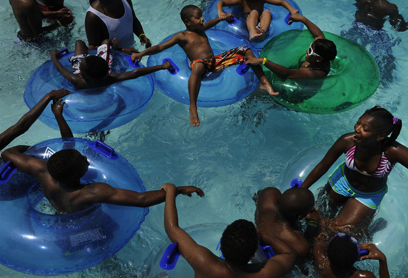Keeping cool in the heat, Tatiyana Allen, 12, far right, plays in the water with others at Great Waves Waterpark at Cameron Run Regional Park on Friday July 29, 2011 in Alexandria, VA.  Temperatures in the area exceeded 100 degrees.  (Photo by Matt McClain/For The Washington Post)