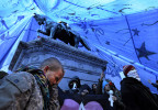 Michael Patterson, left, and other Occupy DC protesters are seen under a tarp covering the statue of Major General James McPherson in McPherson Square on Monday January 30, 2012 in Washington, DC.  The National Park Service issued a noon deadline to enforce no-camping regulations in McPherson Square and Freedom Plaza.  (Photo by Matt McClain for The Washington Post)