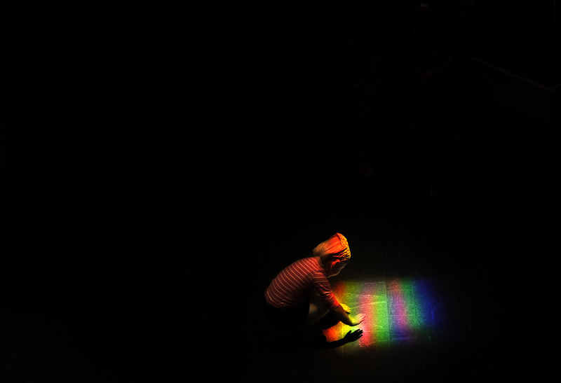 Charlotte Racky, 4, explores a colored pattern of light created by prisms at the Smithsonian's National Museum of the American Indian on Tuesday October 23, 2012 in Washington, DC.  Racky and her family are visiting from Germany.  (Photo by Matt McClain for The Washington Post)
