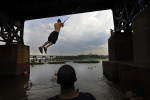 Thomas Johnson of King William, VA watches Justin Bryant of Mechanicsville, MD swing into the James River on Wednesday July 18, 2012 in Richmond, VA.  (Photo by Matt McClain for The Washington Post)
