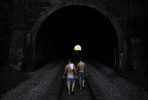 Cody Yeagle, center left, and Mike Bretado, center right, walk towards the Henryton Tunnel while leaving a swimming hole in the Patapsco River in Carroll County, MD on Monday July 16, 2012.  Swimmers walk through the tunnel to get from one well known swimming hole to another.  The tunnel was constructed in the mid-1800's by the Baltimore and Ohio Railroad.  It has gone through some changes since then, including being rebuilt in 1903.  It is still in use today.  (Photo by Matt McClain for The Washington Post)