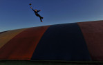 Owen Marino, 12, of Arlington, VA stretches out to catch a football as he plays on {quote}The Jumping Pillow{quote} at Ticonderoga Farms on Sunday November 25, 2012 in Chantilly, VA.  The farm has over 4,000 trees that can be picked out and cut.  (Photo by Matt McClain for The Washington Post)