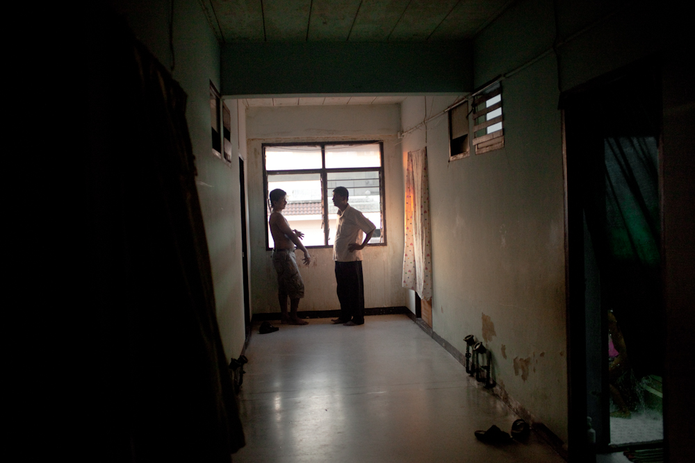 Two men from Sri Lanka stand near a window in the hallway of one of the main buildings, that house hundreds of asylum-seekers. Apr. 2015
