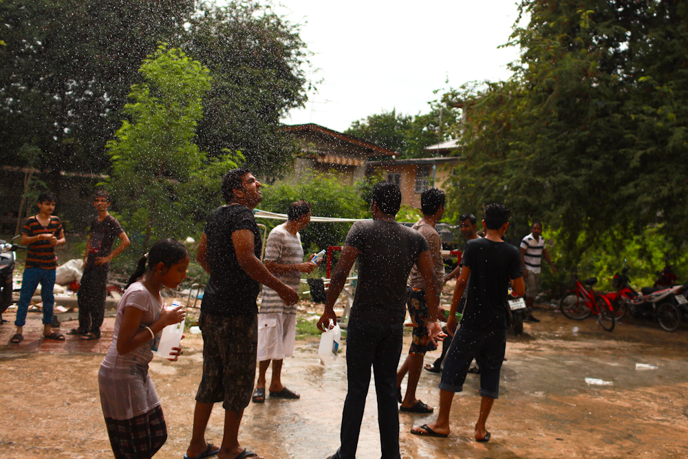 A group of asylum-seekers enjoy a day of water festivities in front of their building during Songkran, Thai New Year. Apr. 2015
