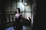 A young boy stands for a portait in a dilapidated apartment buildning in Havana, Cuba. 2009